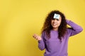 Emotional African-American woman with question mark sticker on forehead against background. Space for text Royalty Free Stock Photo