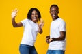 Emotional african man and woman dancing and singing on yellow Royalty Free Stock Photo