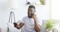 Emotional african soccer fan watching football on tv at home Royalty Free Stock Photo