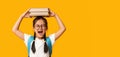 Emotional Asian Schoolgirl Screaming Posing With Books Over Yellow Background