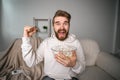 Emotional bearded man watching sport channels on Tv, supporting team at home. Sports fan and championship concept. Royalty Free Stock Photo