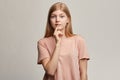 Emotional beautiful woman keeps finger on lips, shows silence gesture, Royalty Free Stock Photo