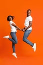 Emotional black couple in love holding hands and jumping up Royalty Free Stock Photo