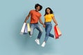 Emotional black couple with shopping bags jumping up Royalty Free Stock Photo