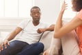 Emotional black couple talking on sofa at home Royalty Free Stock Photo