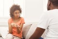 Emotional black couple talking on sofa at home Royalty Free Stock Photo