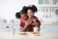 Emotional black daughter hugging her happy mom