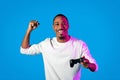 Emotional black guy playing video game on blue background Royalty Free Stock Photo