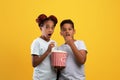 Emotional black kids boy and girl eating popcorn, watching movie Royalty Free Stock Photo