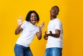 Emotional black man and woman dancing and singing on yellow Royalty Free Stock Photo