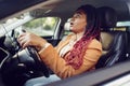 Emotional black woman sitting in a car