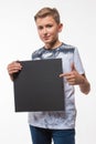 Emotional blond boy in a white shirt with a gray sheet of paper for notes Royalty Free Stock Photo