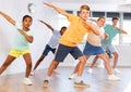 Cheerful tween boy doing dabbing move during dance with group of children