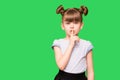 Emotional child girl has secret. Little girl with wonder face keeps finger on lips, shows silence sign, asks to be quiet and stop