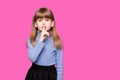 Emotional child girl has secret. Little girl with wonder face keeps finger on lips, shows silence sign, asks to be quiet and stop