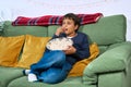 Emotional child watching tv on the sofa and eating popcorn at home, free space