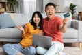 Emotional chinese spouses shopping on Internet from home Royalty Free Stock Photo