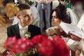 Emotional couple at wedding ceremony in christian catholic church, taking vows with priest and holy bible at the altar, faces Royalty Free Stock Photo