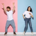 Emotional couple of young funny and happy man and girl dancing hip-hop at studio on blue and pink trendy color Royalty Free Stock Photo