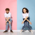 Emotional couple of young funny and happy man and girl dancing hip-hop at studio on blue and pink trendy color Royalty Free Stock Photo