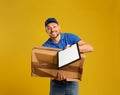 Emotional courier with damaged cardboard box and clipboard on background. Poor quality delivery service Royalty Free Stock Photo