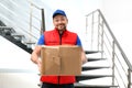 Emotional courier with damaged cardboard box. Poor quality delivery service Royalty Free Stock Photo