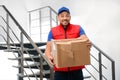 Emotional courier with damaged cardboard box indoors. Poor quality delivery service Royalty Free Stock Photo