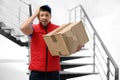 Emotional courier with damaged cardboard box. Poor quality delivery service Royalty Free Stock Photo