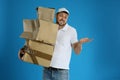 Emotional courier with damaged cardboard boxes on blue. Poor quality delivery service