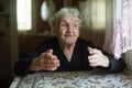 Emotional elderly woman tells gesturing sitting at a table. Help.