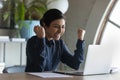 Emotional euphoric young indian ethnic businesswoman looking at laptop screen.