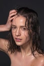 Emotional fashion portrait of beautiful women with bright makeup. Wet hair on her face. Studio photo on a black background.