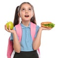 Emotional girl with burger and apple on background. Healthy food for school lunch Royalty Free Stock Photo