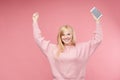 Emotional girl happily raised her hands up holding a mobile phone Royalty Free Stock Photo