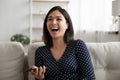 Emotional happy millennial asian woman laughing at funny mobile video.