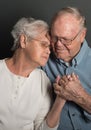 Emotional image of Senior couple holding hands in a tender loving embrace, both wearing glasses, man unshaven Royalty Free Stock Photo