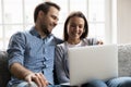 Emotional joyful bonding couple watching comedian movie on laptop.