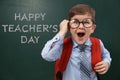 Emotional little child wearing glasses near chalkboard with text Royalty Free Stock Photo