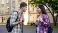 Emotional male student talking with ex-girlfriend near university, relationship