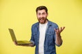 Emotional man holding a laptop and shouting actively gesturing with his hands Royalty Free Stock Photo