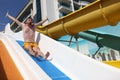 Emotional man screams in horror going down water slide Royalty Free Stock Photo