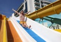 Emotional man screams in horror going down water slide Royalty Free Stock Photo