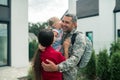 Military man hugging his wife and daughter after returning home Royalty Free Stock Photo