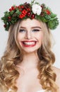 Emotional model woman with long wavy hair, makeup and colorful natural winter decoration having fun on white studio wall Royalty Free Stock Photo