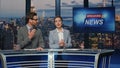 Emotional news readers discussing live tv newscast in night media studio closeup Royalty Free Stock Photo