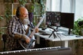 Emotional obese man plays electric guitar in home audio studio Royalty Free Stock Photo