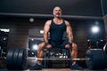 Emotional Older sportsman preparing to exercise deadlift with barbell while on cross training in a gym.
