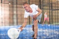 Emotional paddle tennis player swinging white racket on indoor court Royalty Free Stock Photo