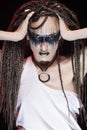 Emotional photo of a beautiful young slim girl with creative make-up and a hairstyle of cornrows, wearing white t-shirt on a black