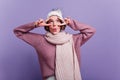 Emotional pleased woman in knitted warm scarf fooling around and making funny faces. Studio shot of wonderful caucasian Royalty Free Stock Photo